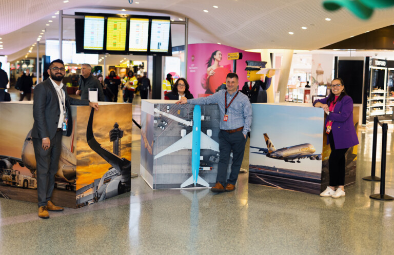 Vincenzo Pace, Director of Airport Solutions at Unity Electric, posing with his aerial photography on display at T4 at JFK.