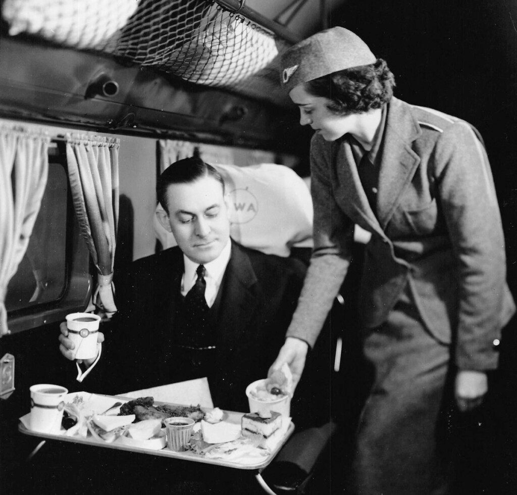 On the Runway - Flying In Fashion New York Airport Stewardess serving passenger on board TWA DC-2 c.1935 (Cradle of Aviation Museum)